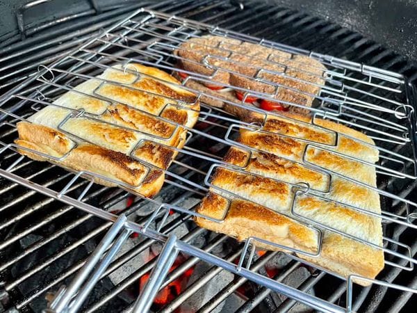 braai broodjies geklemd tussen een rooster boven hete briketten