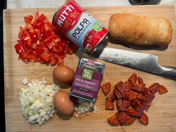 alle ingrediënten voor shakshuka op een houten snijplank