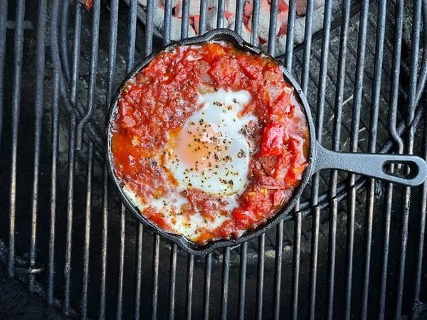 shakshuka in een skillet op de barbecue met een pocheerd ei